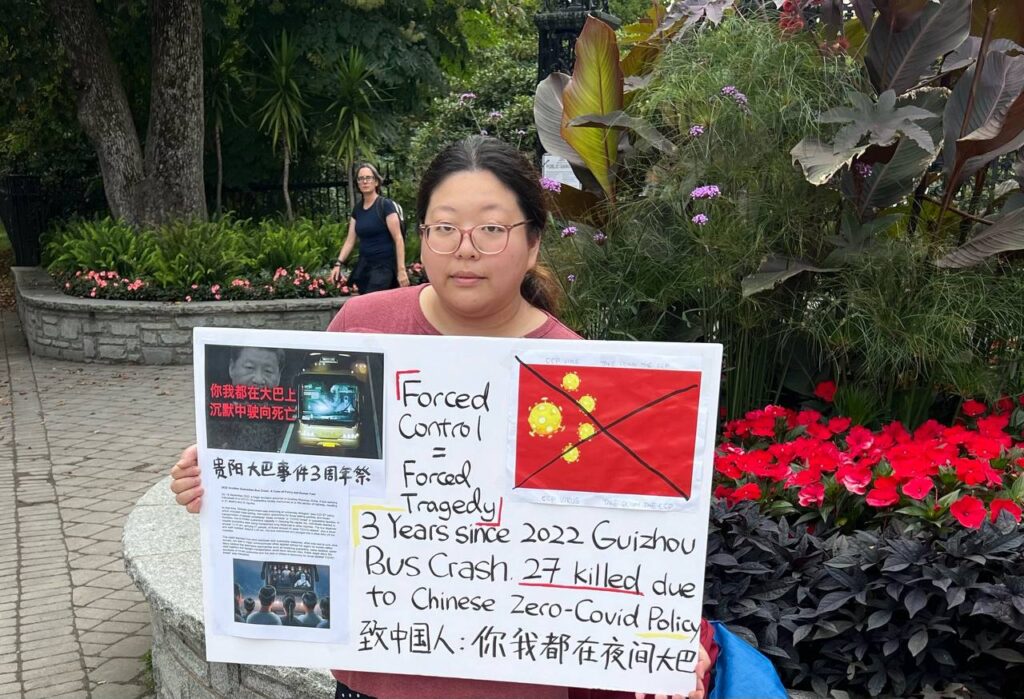 Assembly of Citizens members holding a sign that commemorates the Guizhou bus disaster