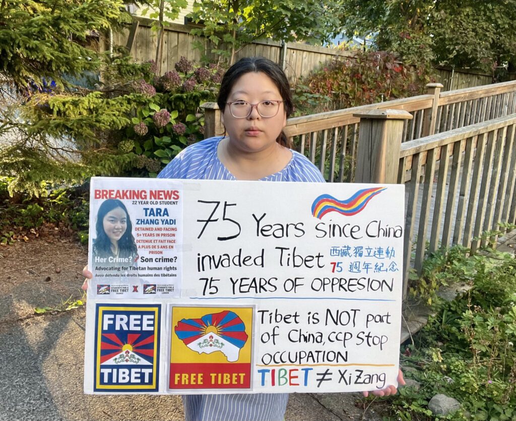 the Halifax regional coordinator of Assembly of Citizens, Ashlynn Peng, holding the banner